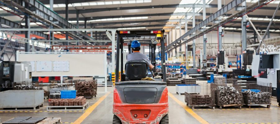 Employee in forklift working on modern factory